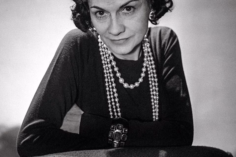 Коко Шанель у чорно-білому кадрі з перловим намистом і капелюхом